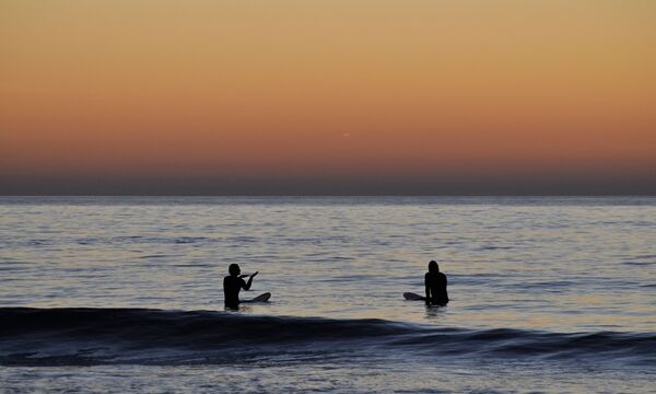 Surfer sitzen im Wasser eines der surfspots spanien