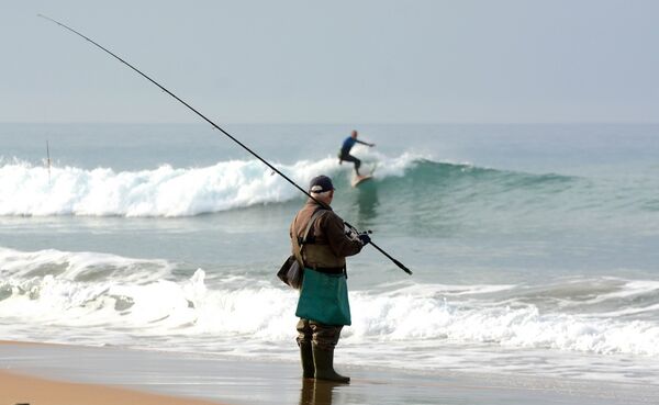 Angler beobachtet Surfern an den surfspots spanien