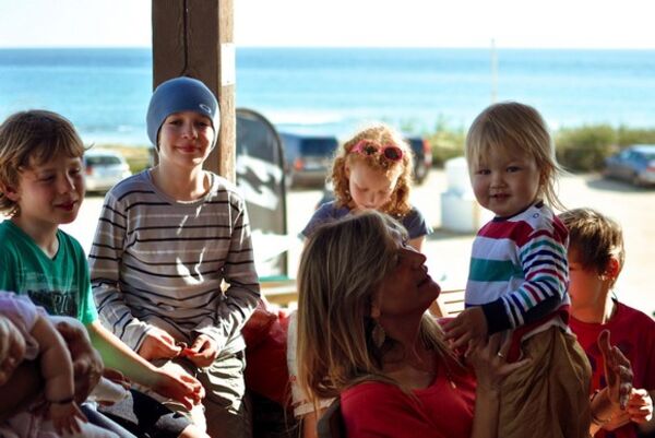 Kinder sitzen auf der Terrasse vom A Frame Surfcamp