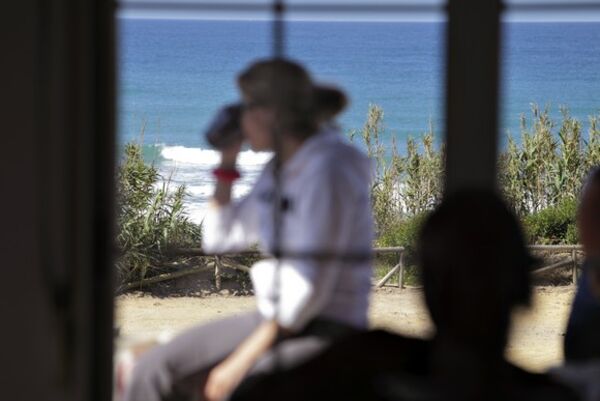 Eine Frau trinkt gemütlich ihren Kaffee auf der Terrasse des A Frame Surfcamp