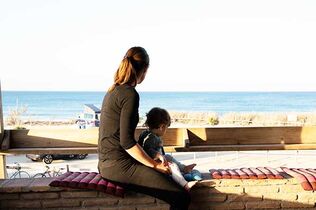 Mutter und Kleinkind auf Terrasse am Meer