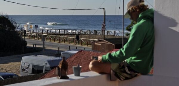 Mann auf dem Balkon vom A Frame Surfcamp