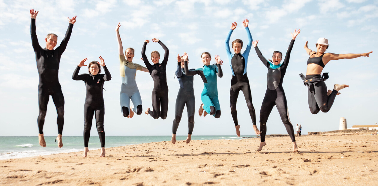Kids and adults jumping on the sand in El Palmar