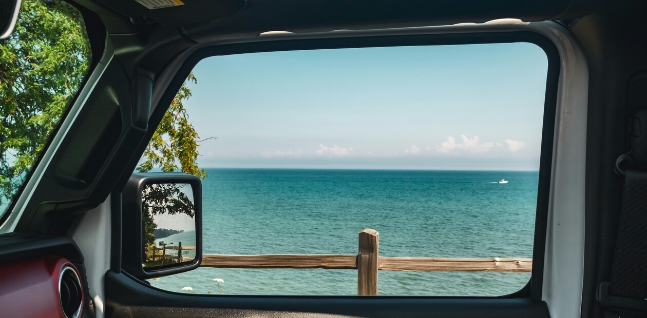 Blick aus dem Beifahrerfenster auf Strand und Meer