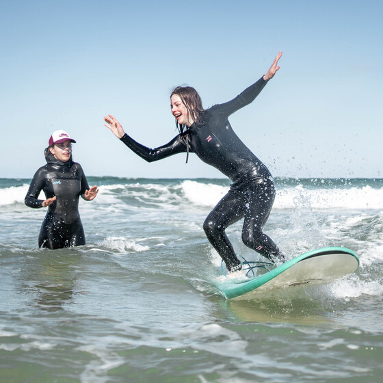 Conil surfen, Surfkurs, Surflehrerin erklärt Schülerin das Surfen