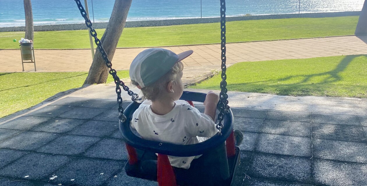 Conil Atalaya, Kind schaukelt mit Blick auf das Meer