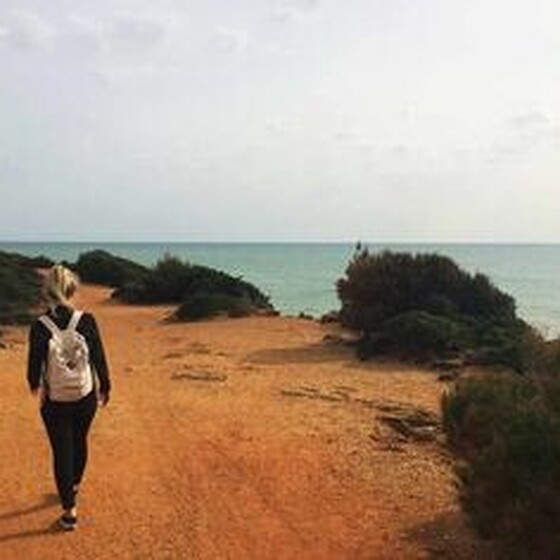 Wandern in Conil, Frau läuft an den Klippen lang