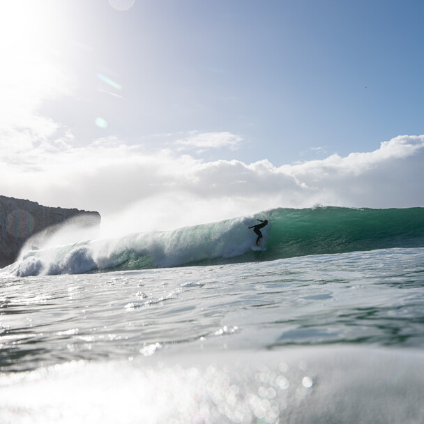 Surfer startet auf Welle, vom Wasserfotografen aufgenommen