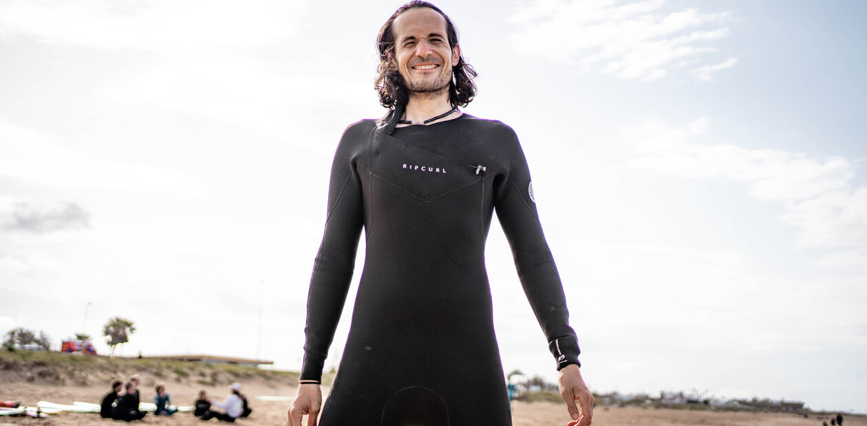 Mann mit Neoprenanzug am Strand