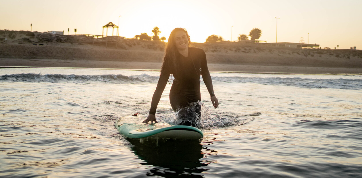 Glückliche Surferin dank Packliste für Surfurlaub