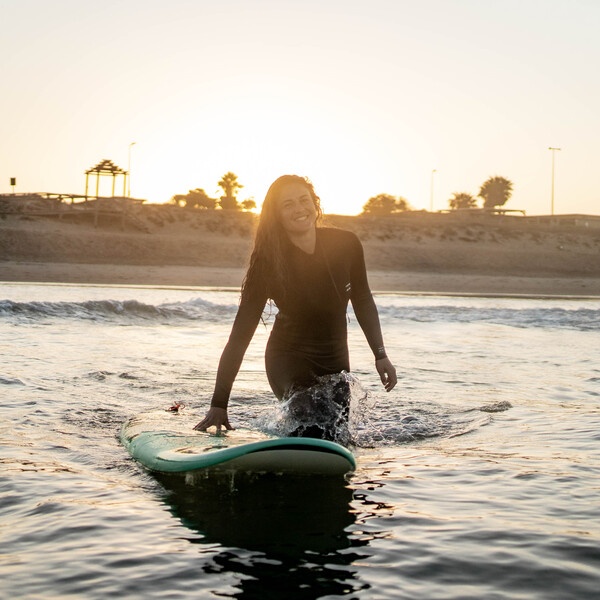 Glückliche Surferin dank Packliste für Surfurlaub