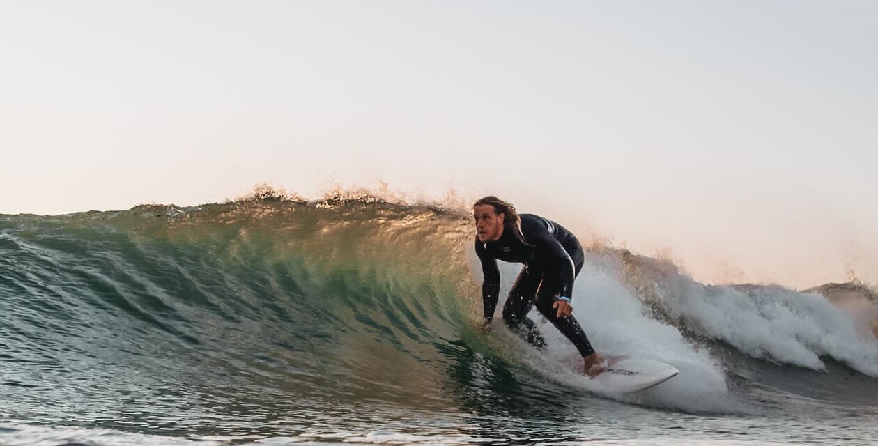 Surfer mit Shortboard in Welle, Packliste für Surfurlaub