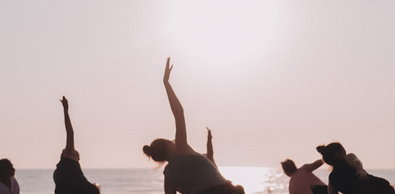 Yoga Übungen bei Sonnenuntergang am Meer im Surf Yoga Retreat