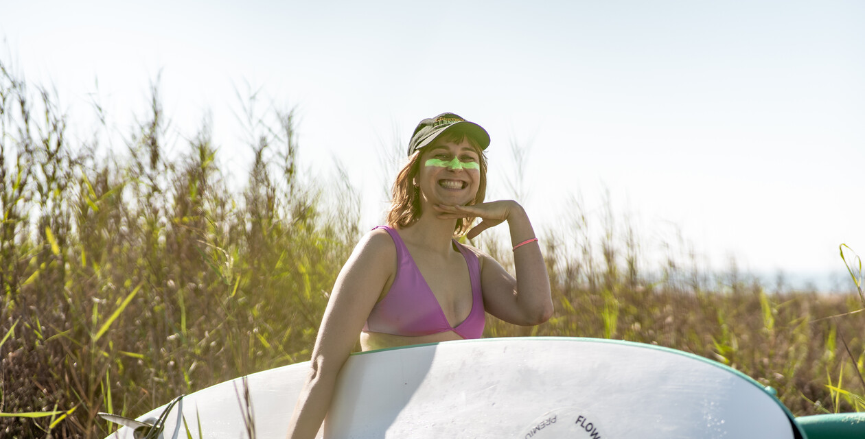 Frau auf Welle hat Spaß beim Surfen im Surf & Yoga Retreat