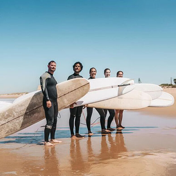 longboard surfkurs spanien, Gruppe Surfer mit Surfbrett