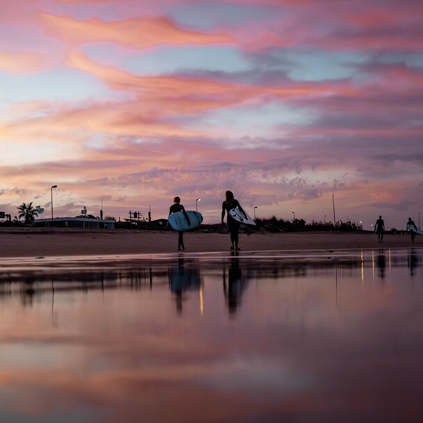 Surfer im Sonnenuntergang am Strand, Surfcamp Andalusien