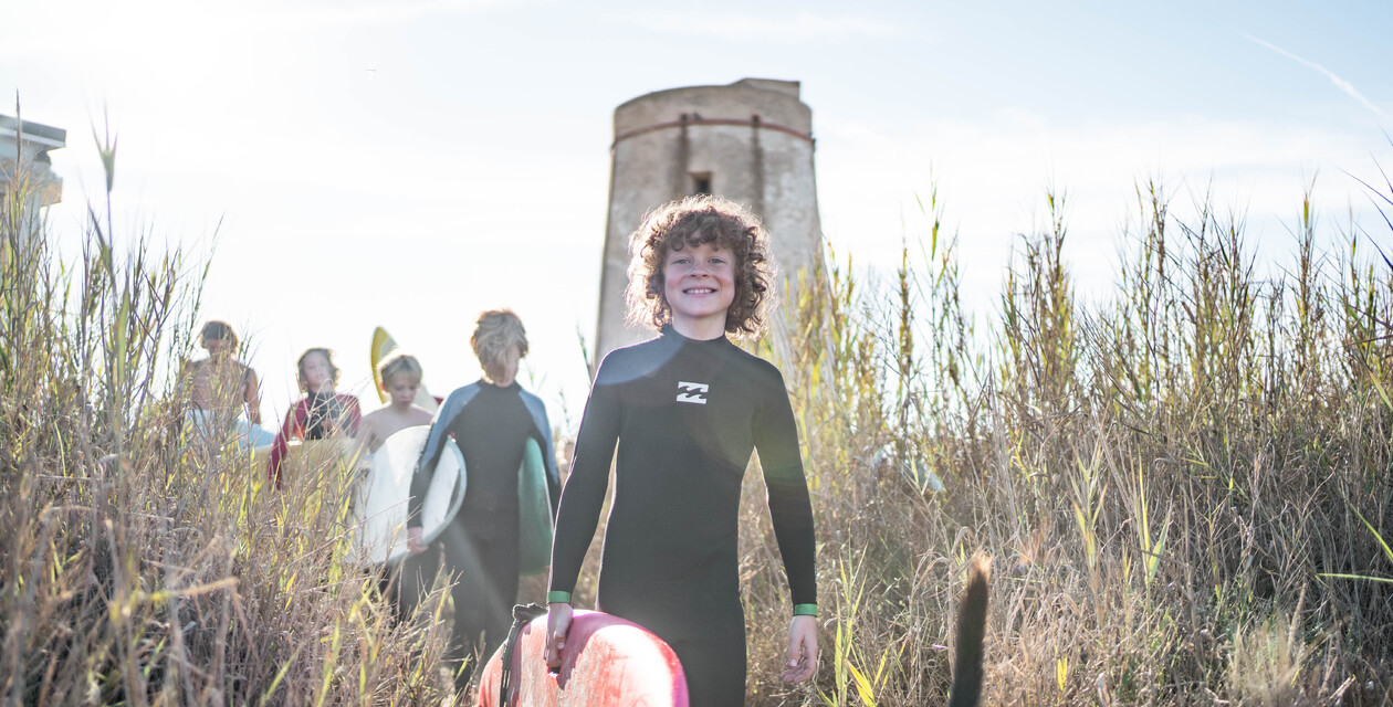 Kinder auf dem Weg zum Surfkurs im Familiensurfcamp El Palmar