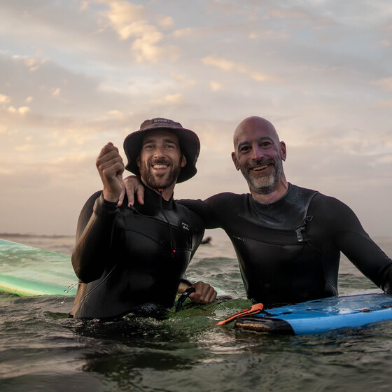 Zwei Männer im Wasser lachen, Surfcamps Erwachsene