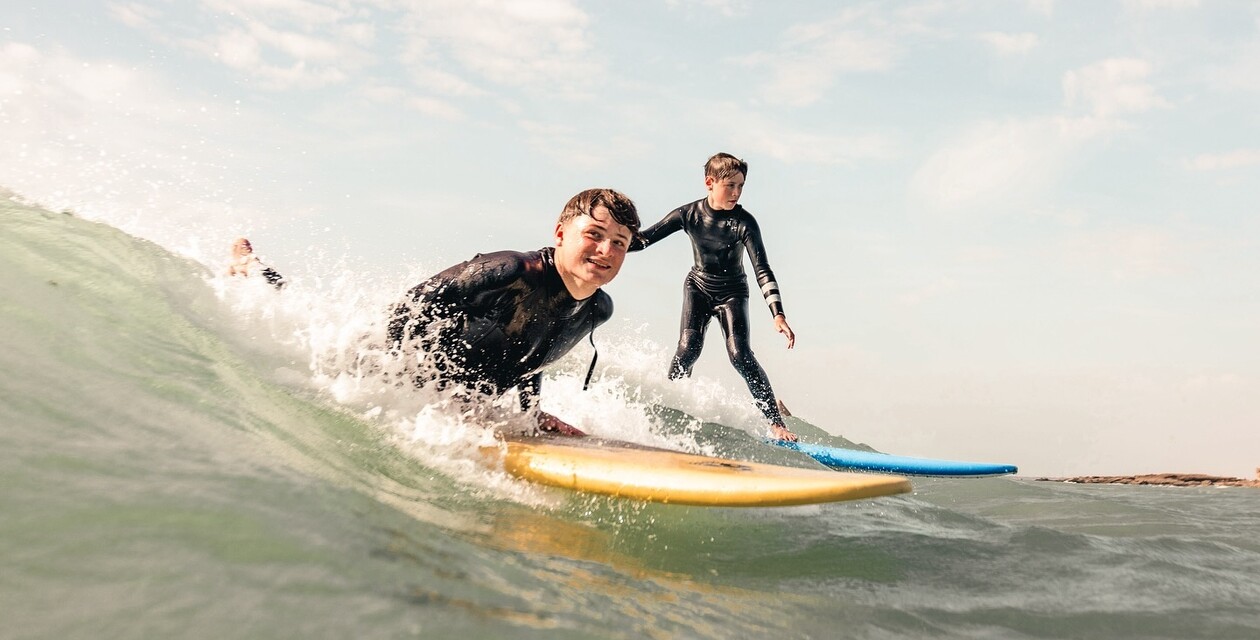 Zwei Jungs auf Surfbrettern in Welle, Surfcamps Erwachsene