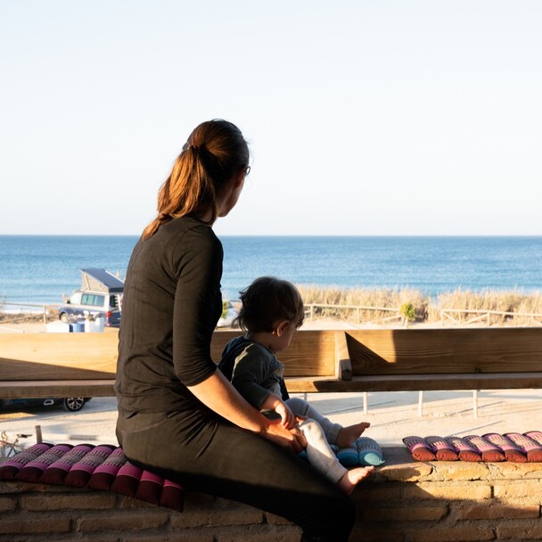 Familie mit Kleinkind auf der Terrasse im Surfcamp