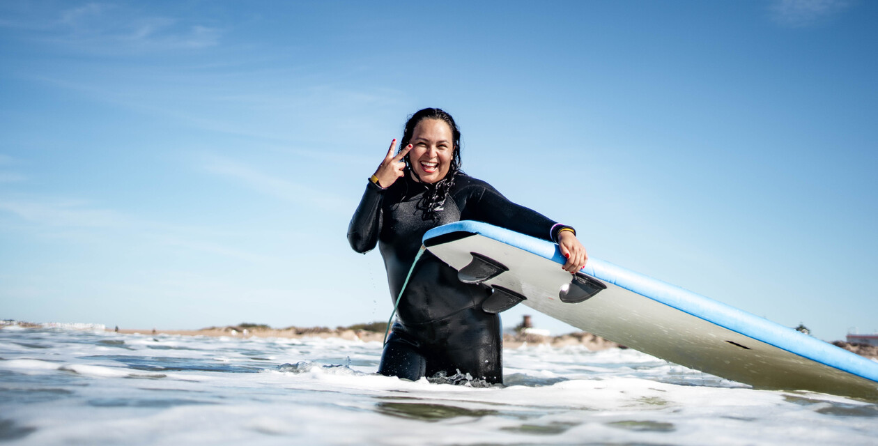 Surferin lacht und grüßt, Surfen Andalusien