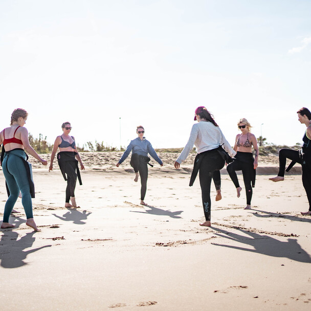 Warm-up beim Surfen lernen am Strand