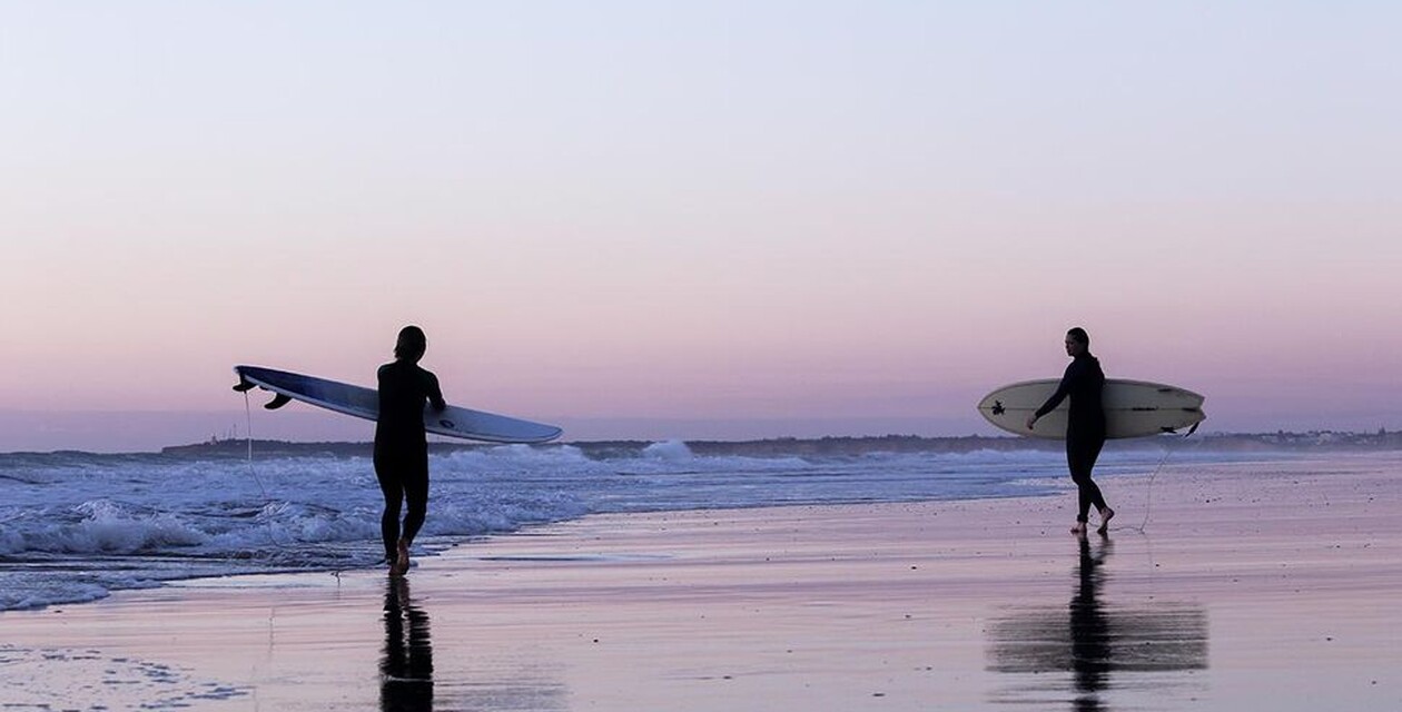 Sonnenuntergang am Strand, zwei Surfer