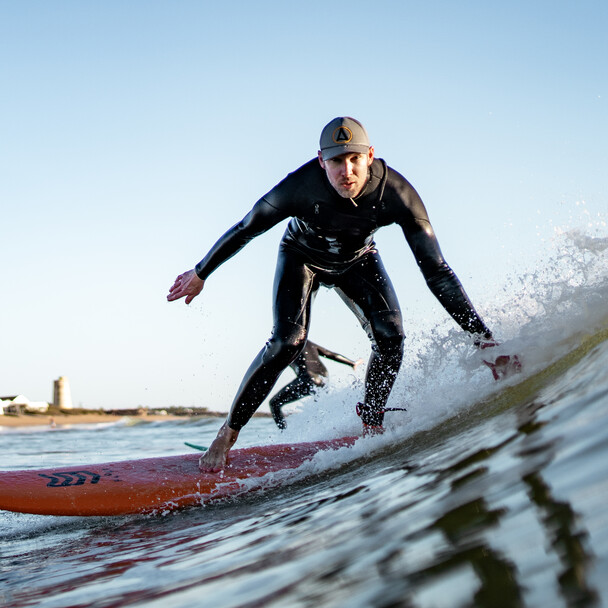 Surfer in großer grüner Welle, Surfkurs