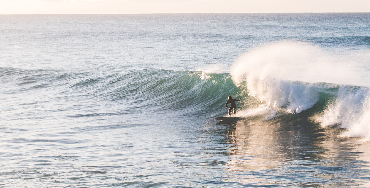 Surfer in großer Welle mit Spray, Surfkurs Fortgeschrittene