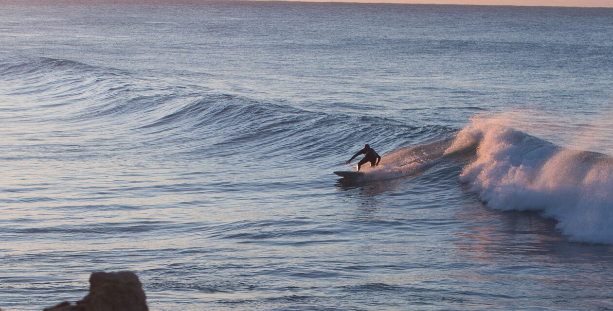 Surfer in großer Welle nach dem Surfspot Check