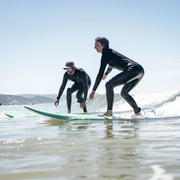 Surflehrer und Frau auf Surfbrett beim Surfkurs in El Palmar de Vejer