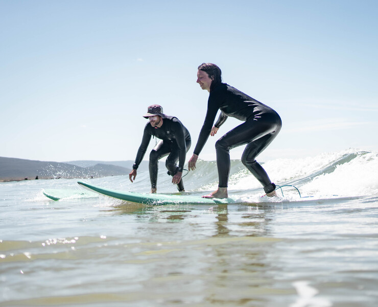 Surf camp with surf course, accommodation, catering, surf students in the water