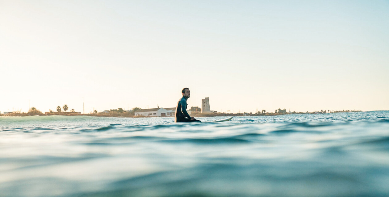 Surfcamp Andalusia A-Frame, single surfer in the water waiting for the next wave