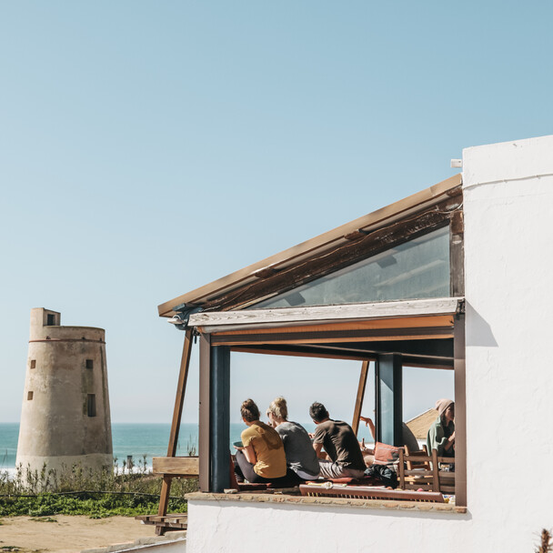 A-Frame Surfcamp Andalusia, terrace with views of the tower and the sea