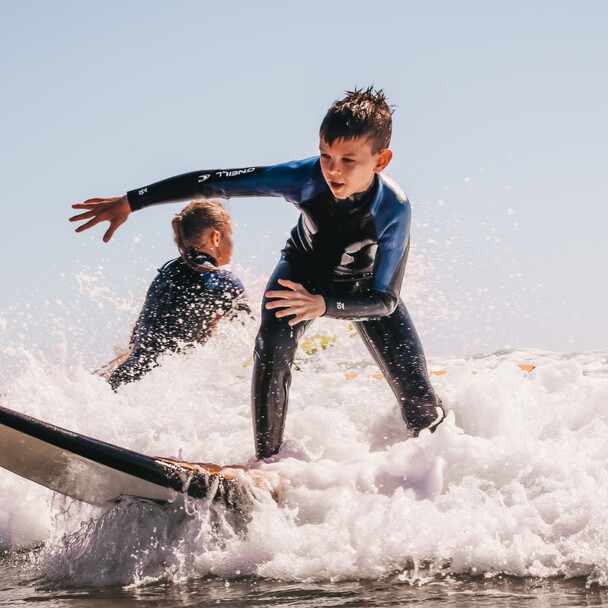 Surfcamp Spanien, Surfkurs für alle Levels, Kind übt Surfen