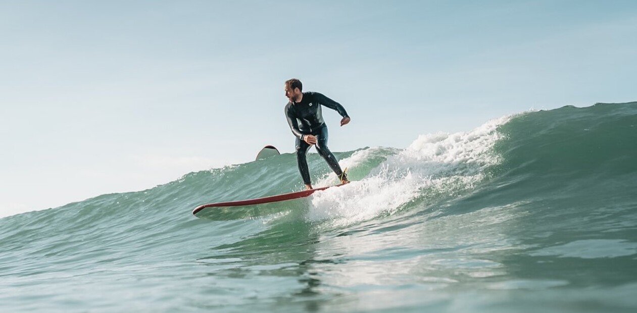 surfen lernen im meer, surfer im wasser in grüner Welle