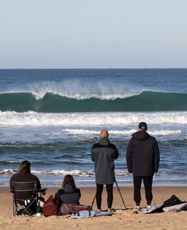 Surf instructor training on the beach of El Palmar, surfers in the water, instructors on the beach