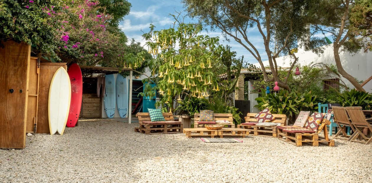 Surfcamp Spanien, Strand Surfcamp, Blick auf die Chill Area im Garten und Surfboards