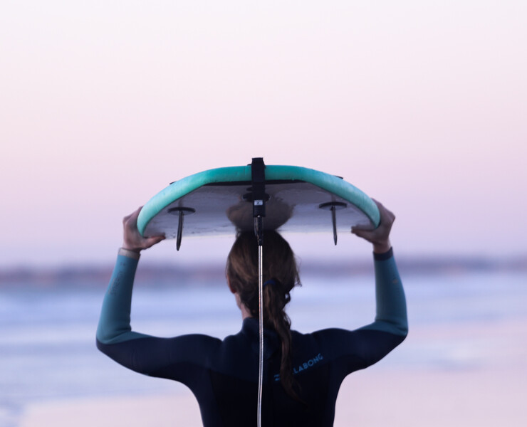 Yoga surf retreat, yoga and surfing, woman with surfboard