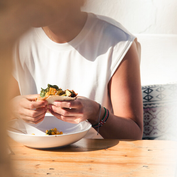 Healthy nutrition for body and soul at the yoga and surf retreat, woman eats healthy tacos